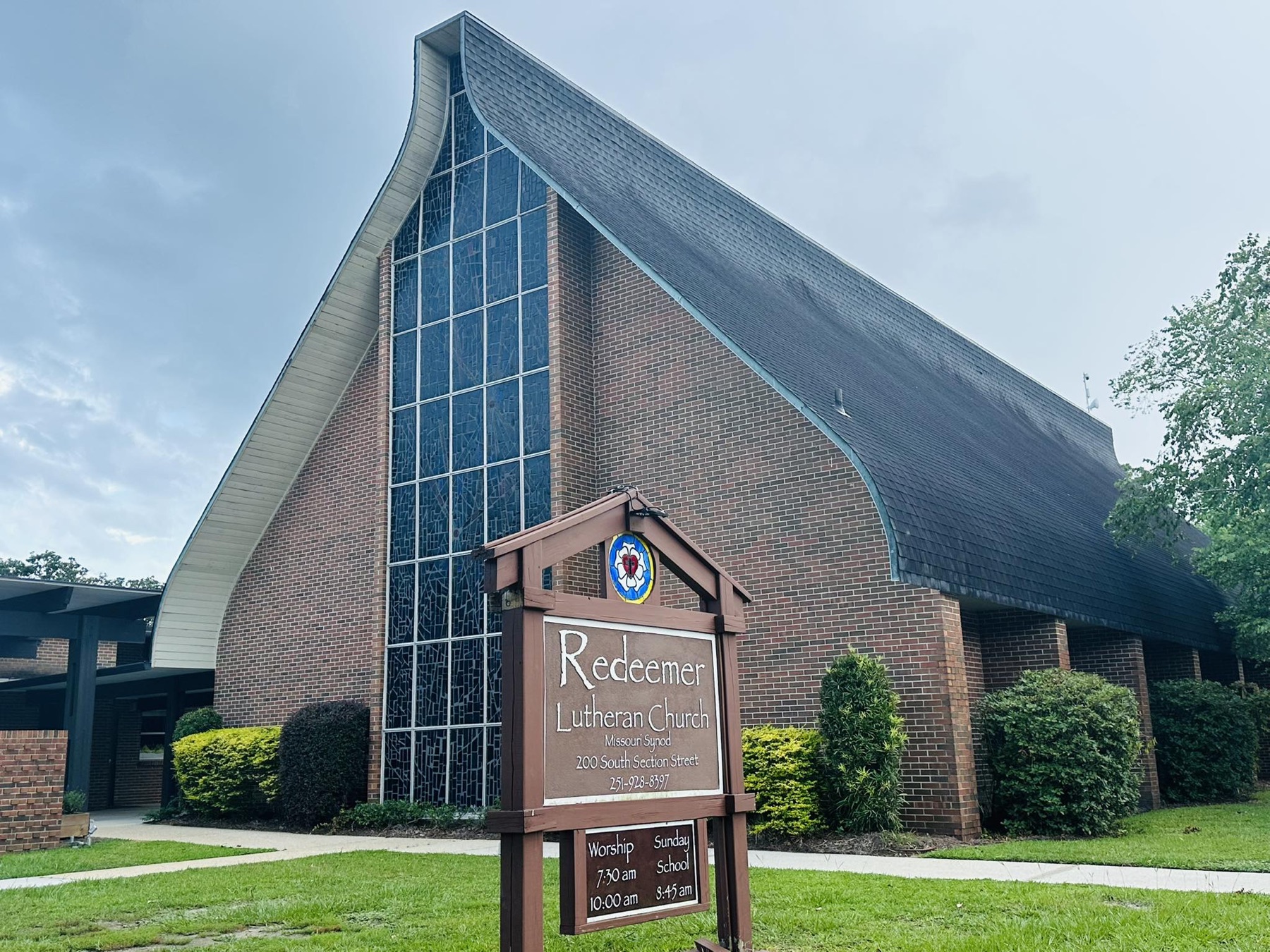Redeemer’s distinctive church roofline and stained-glass window in Fairhope
